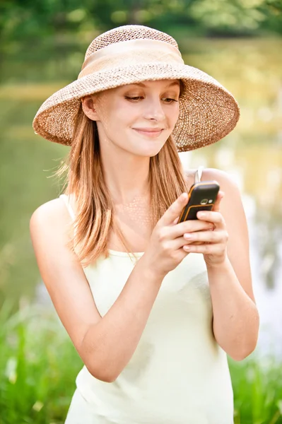 Κορίτσι στο ψάθινο καπέλο με τηλέφωνο — Φωτογραφία Αρχείου