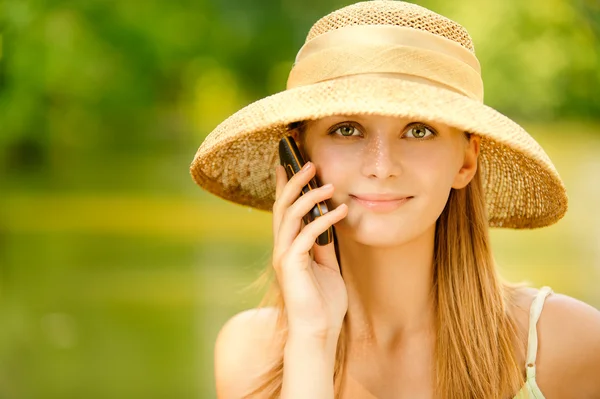 Menina em chapéu de palha com telefone — Fotografia de Stock
