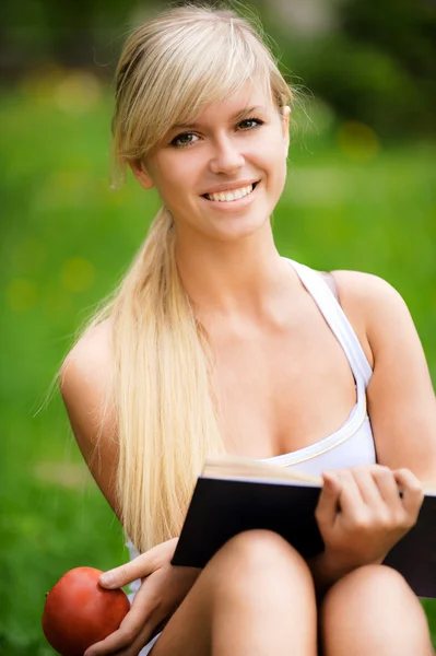 Girl with book and apple — Stock Photo, Image