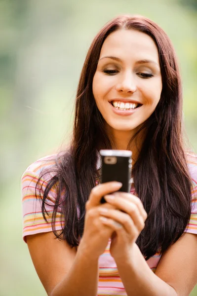 Όμορφη νεαρή γυναίκα διαβάζει sms — Φωτογραφία Αρχείου