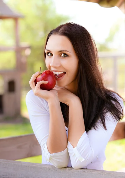 Mujer joven muerde manzana — Foto de Stock