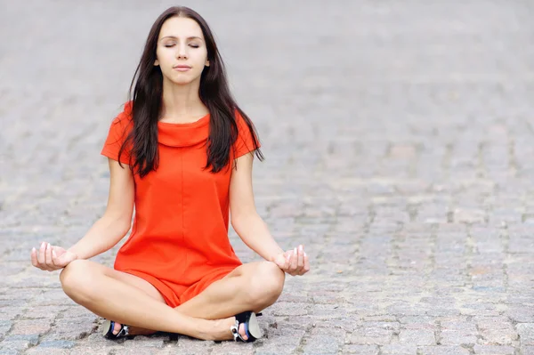 Kvinna i röd klänning mediterar — Stockfoto