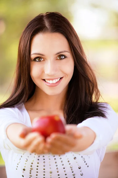 Mladá žena se táhne jablko — Stock fotografie
