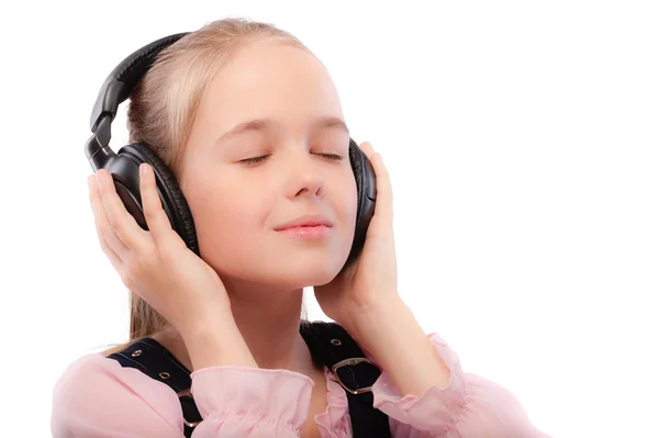 Joven hermosa colegiala escucha música en los auriculares —  Fotos de Stock