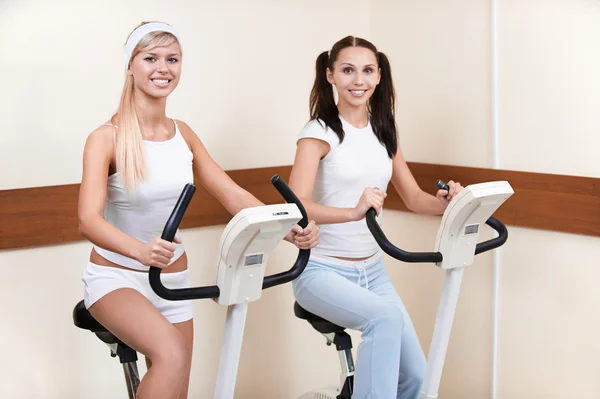 Chicas en bicicletas de ejercicio — Foto de Stock