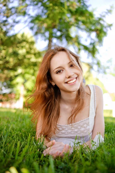 Schönes Mädchen liegt auf dem Rasen — Stockfoto
