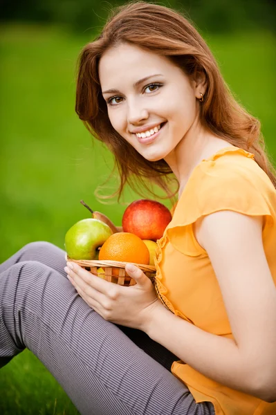 Девушка с яблоками в корзине — стоковое фото
