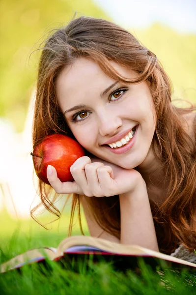 Meisje met boek en apple — Stockfoto