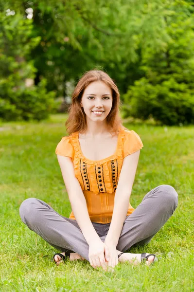 Piękna dziewczyna siedzi na trawnik — Zdjęcie stockowe