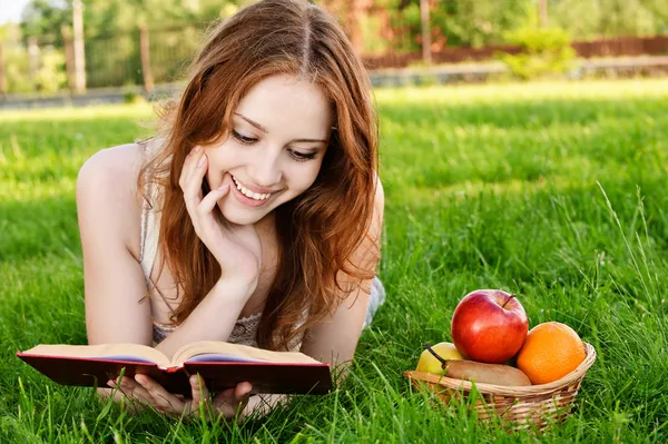 Menina com livro e maçãs — Fotografia de Stock