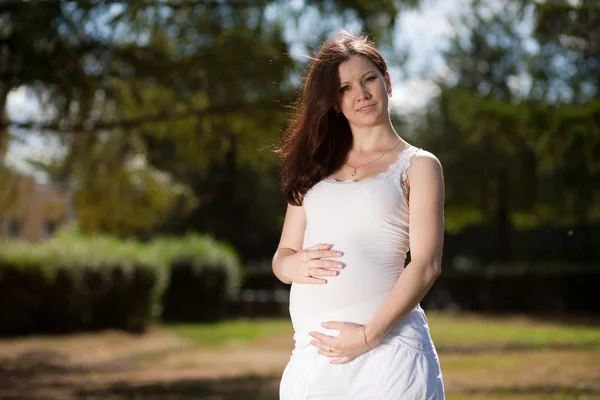 Mujer embarazada hermosa en el parque — Foto de Stock