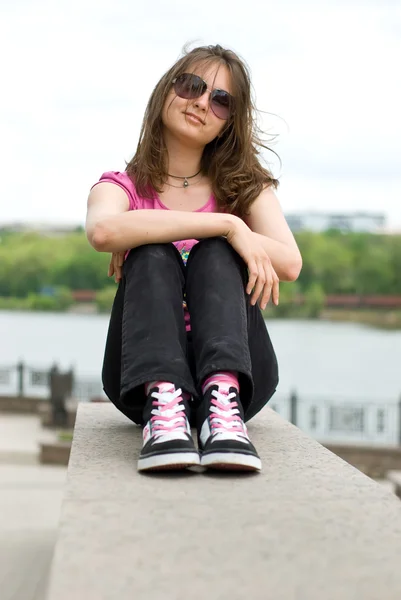 Девочка-подросток в солнечных очках и кроссовках — стоковое фото
