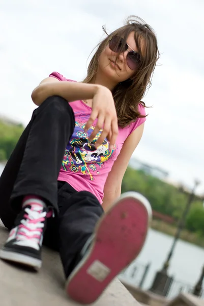 Teenage girl in sunglasses and sneakers — Stock Photo, Image