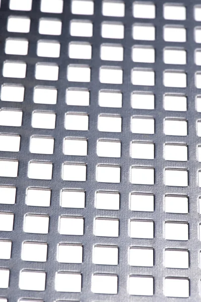 Geperforeerd metaal op witte close up — Stockfoto