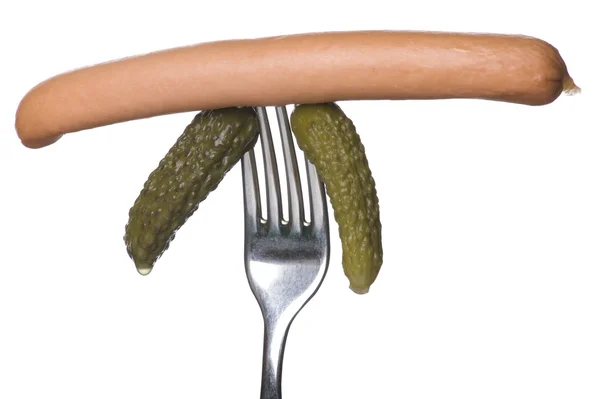 Frankfurter and cucumber on fork — Stock Photo, Image