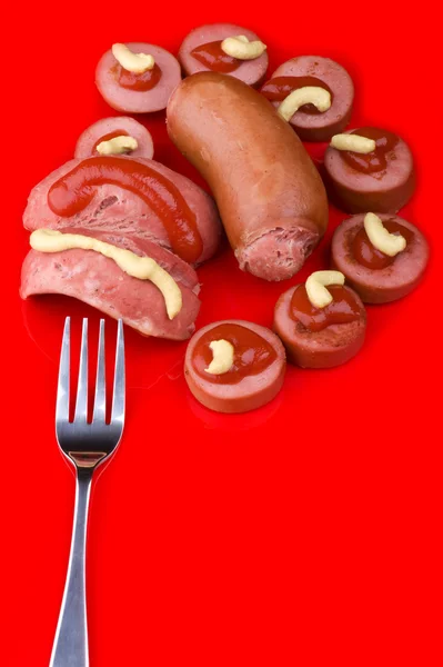 Cutting sausage on red background — Stock Photo, Image