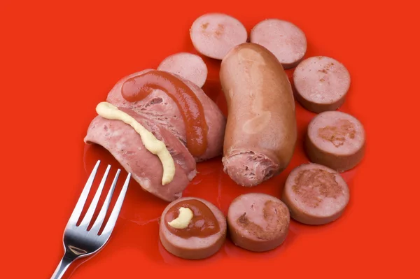 Cutting sausage on red close up — Stock Photo, Image
