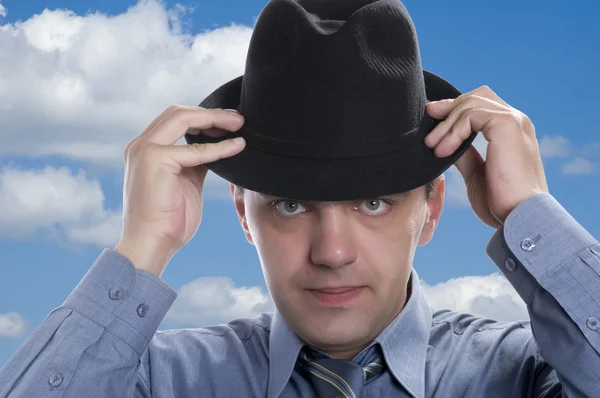 Men on black hat on sky — Stock Photo, Image