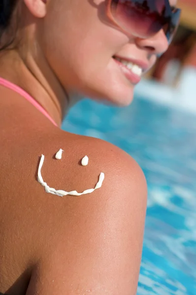Улыбка с солнцезащитным кремом на плече — стоковое фото