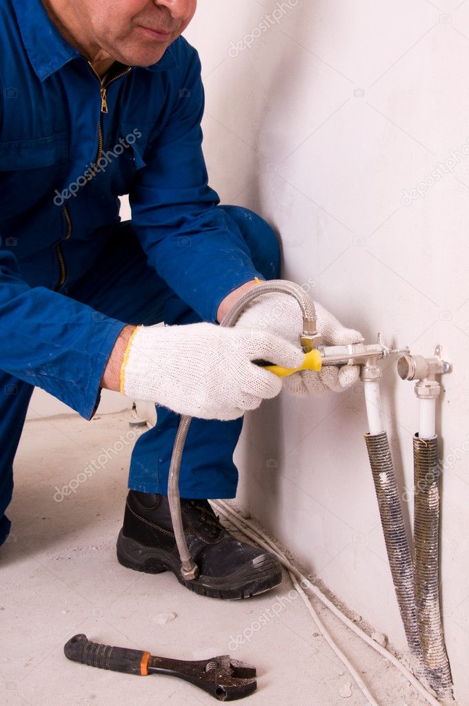 Plumber fixing water pipe