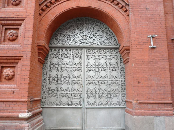 Edifício de tijolo vermelho velho com portão sectile — Fotografia de Stock