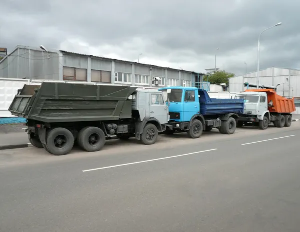 Серые, синие и оранжевые грузовики — стоковое фото