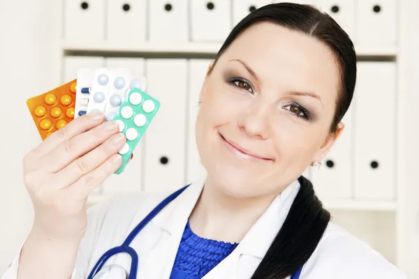 Médico mulher segurando pílulas — Fotografia de Stock