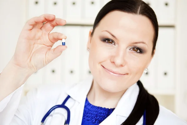 Médico mulher segurando pílula — Fotografia de Stock