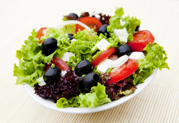 Salad in plate on mat — Stock Photo, Image