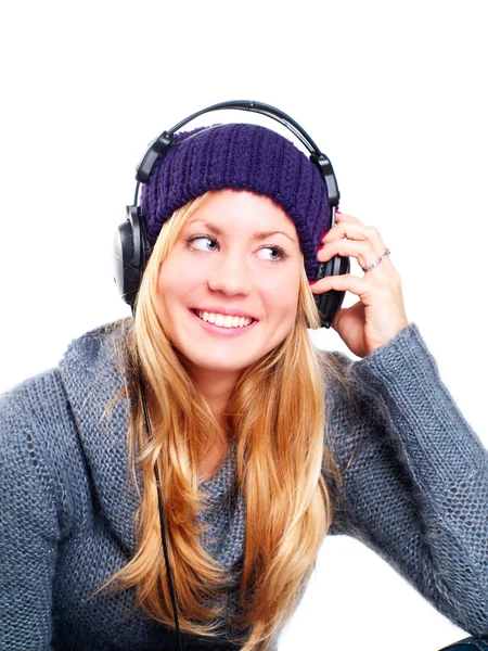 Mujer rubia con auriculares escuchando música sobre blanco — Foto de Stock