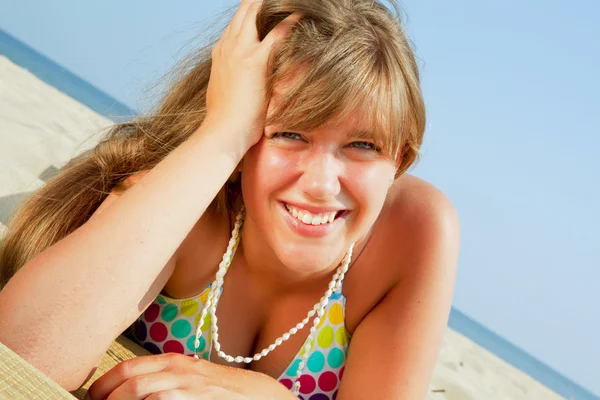 Χαμογελώντας η νεαρή γυναίκα στην παραλία — Φωτογραφία Αρχείου