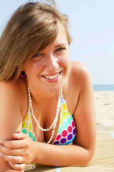 Lächelnde junge Frau am Strand — Stockfoto