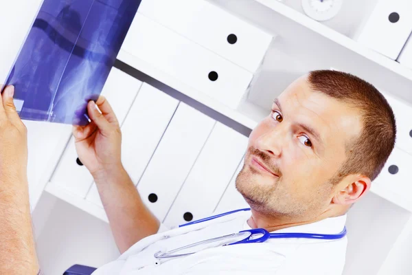 Homme médecin tenant rayons X dans le bureau — Photo