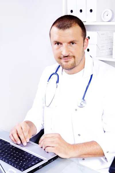 Guapo médico masculino trabajando en el consultorio — Foto de Stock