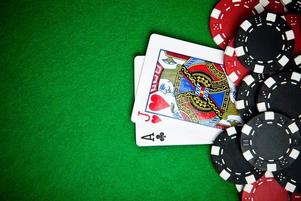 Black and red poker chips with cards in the back — Stock Photo, Image