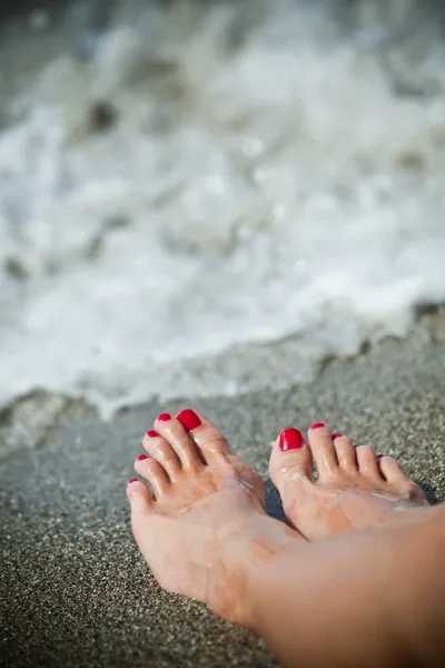 Los pies de mujer - día solitario en la playa Imágenes de stock libres de derechos