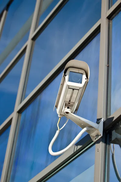 Security camera attached on business building with reflections — Stock Photo, Image