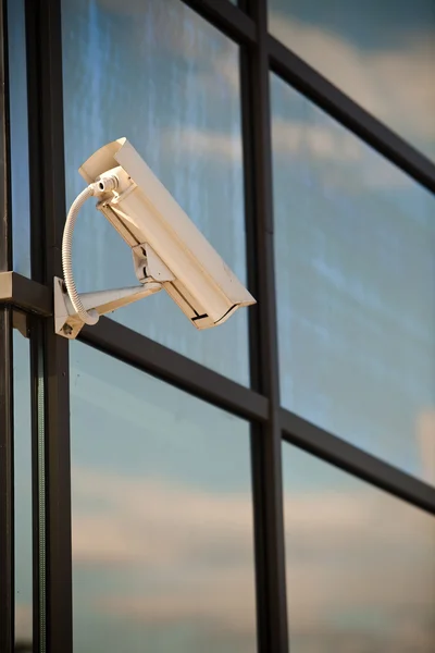 Überwachungskamera an Geschäftshaus mit Spiegelungen angebracht — Stockfoto