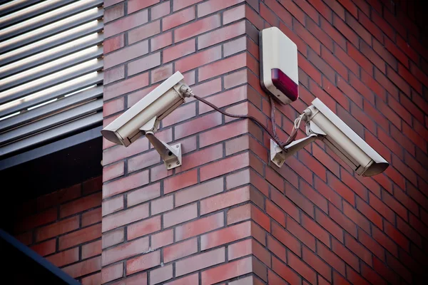 Dva bezpečnostní kamery připojené na cihlovou zeď — Stock fotografie