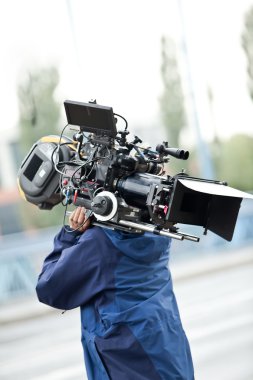Camera operator carrying equipment clipart