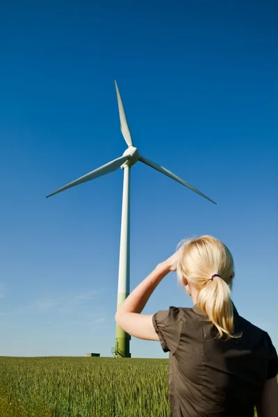 Женщина инженер смотрит на ветряную турбину - альтернативный и зеленый ru Лицензионные Стоковые Фото