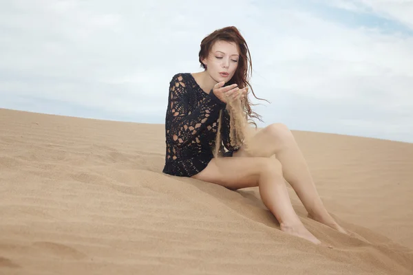 Senhora soprando em grãos de areia — Fotografia de Stock