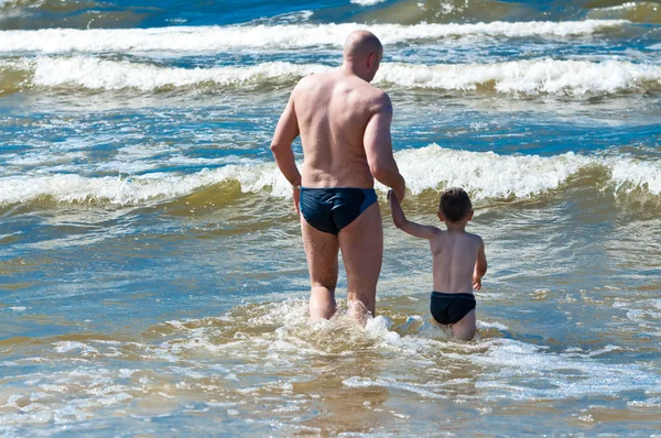 stock image Father playing with son on the sea