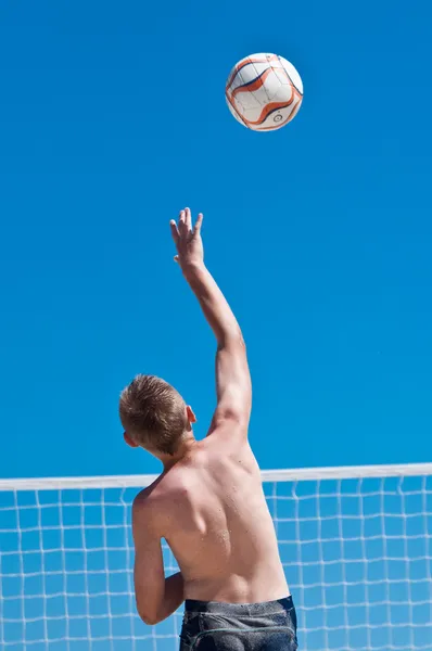 Ung pojke spela volleyboll på stranden — Stockfoto