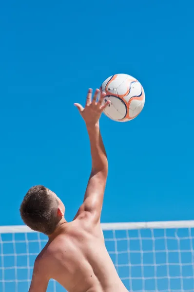 Fiatal fiú röplabdázás a strandon — Stock Fotó