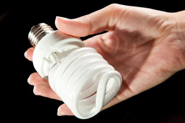 Энергосберегающая лампочка в руке — стоковое фото