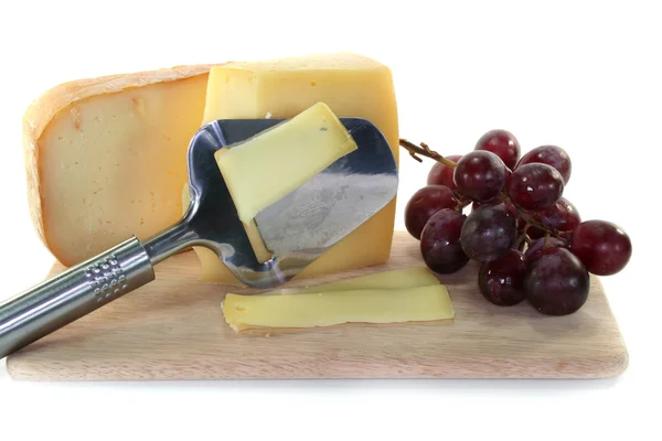 Cheese with a cheese slicer — Stock Photo, Image
