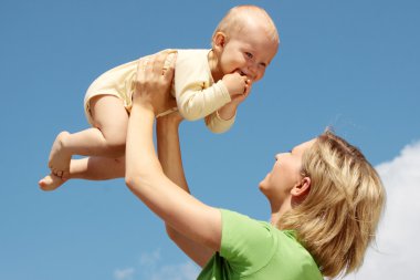 Anne ile bebek mavi gökyüzü altında