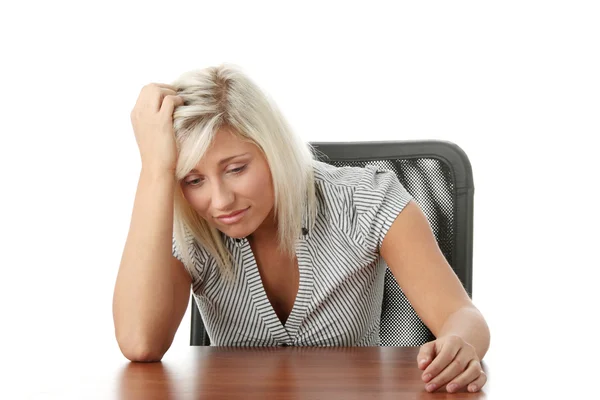 Stressato giovane donna seduta dietro una scrivania — Foto Stock