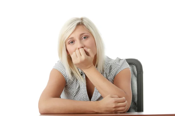 Stressato giovane donna seduta dietro una scrivania — Foto Stock